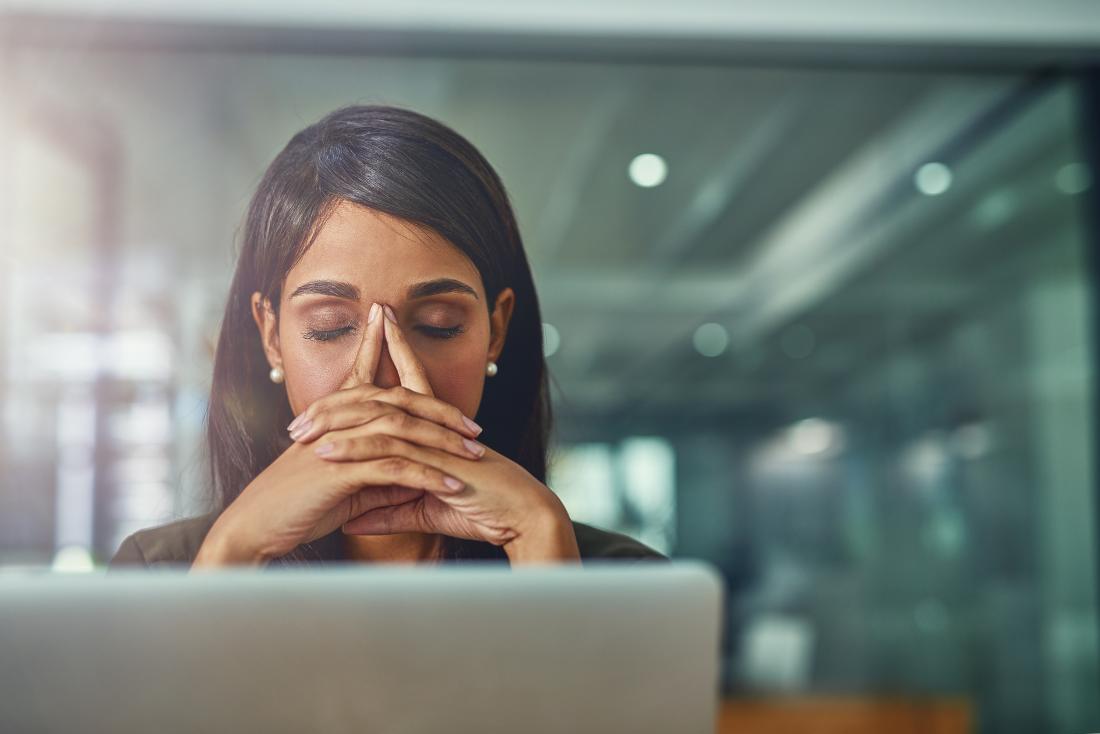 woman with gerd and fatigue at computer looking tired