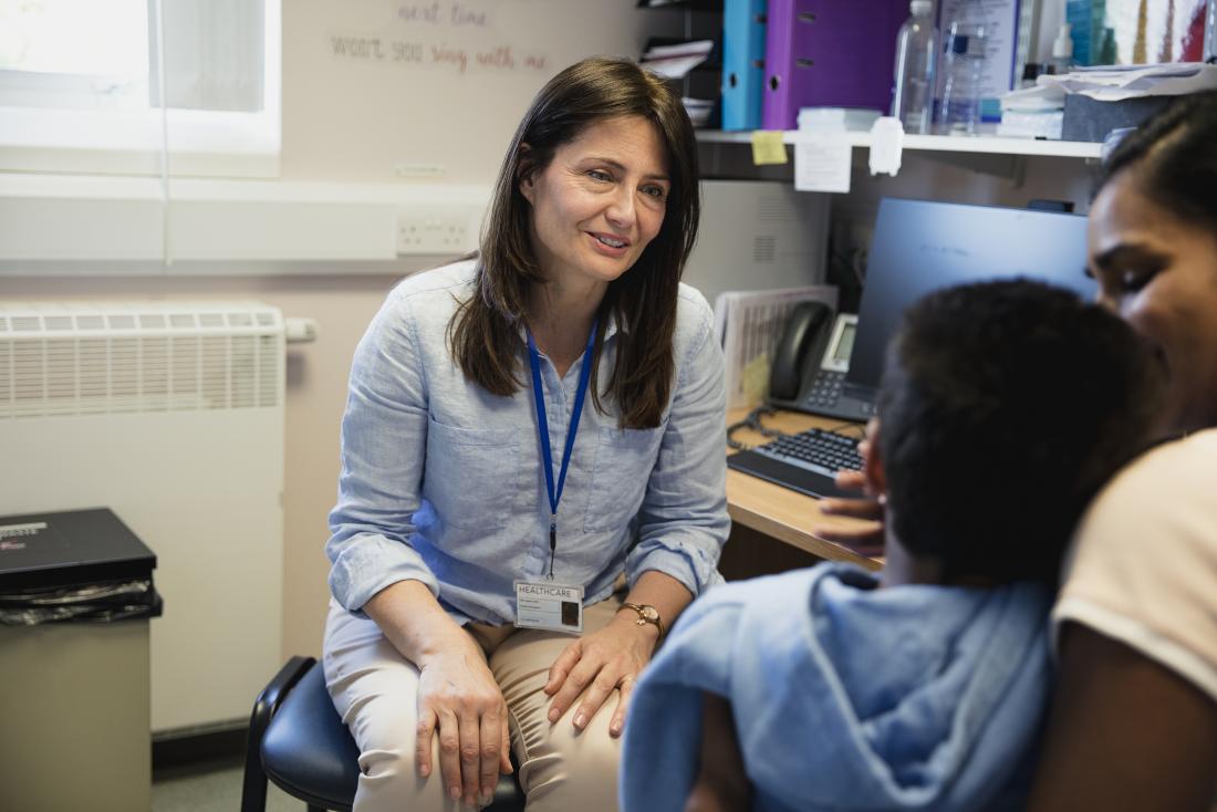 Doctor in office talking to mother and child.