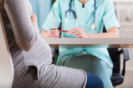 pregnant woman speaking to doctor
