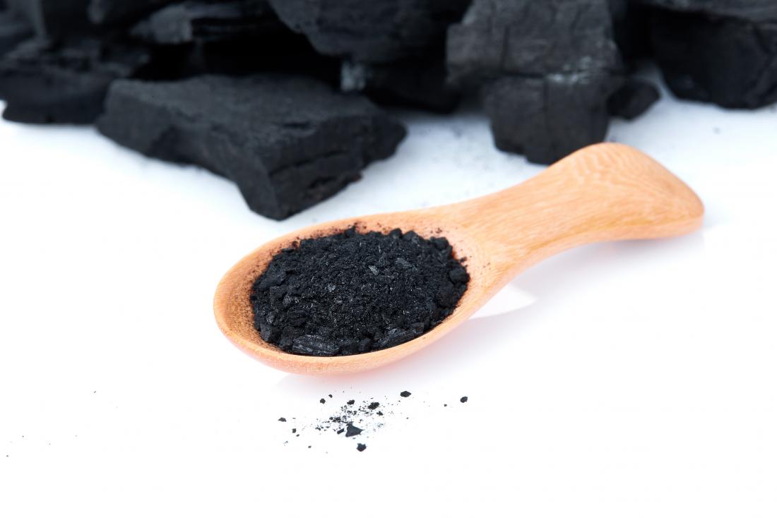 Activated charcoal in wooden spoon.