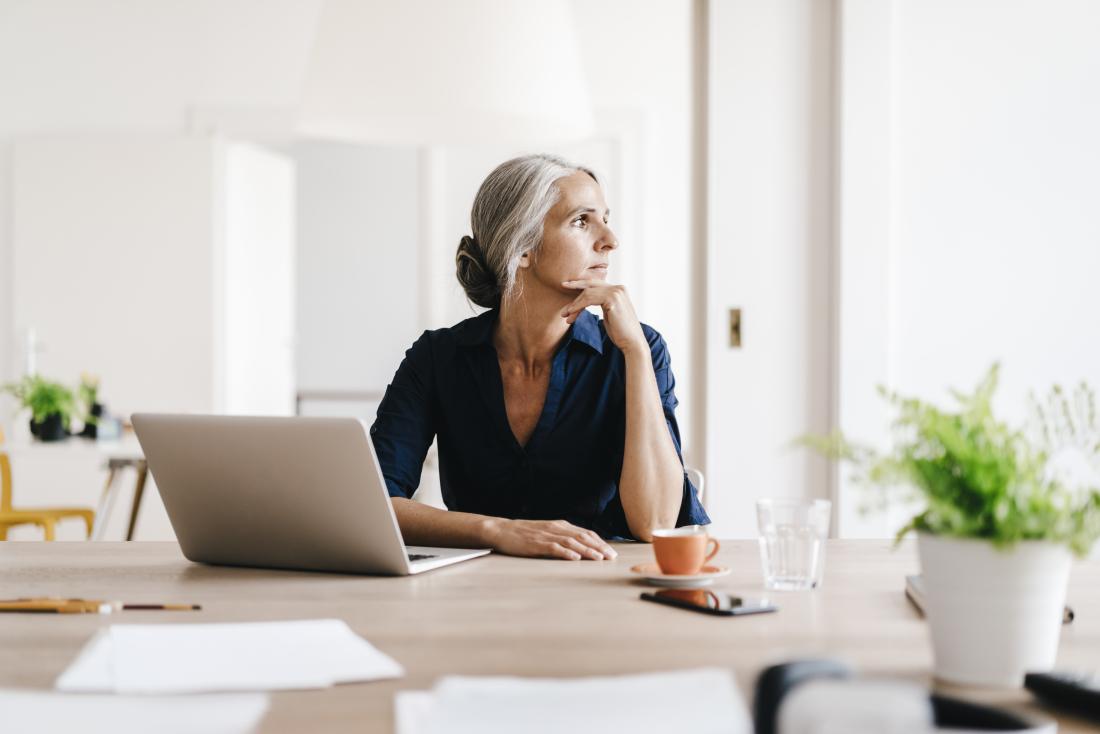 Mature post-menopausal woman sitting in office.