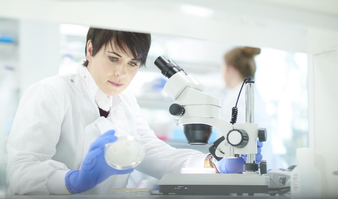 researcher with microscope and petri dish