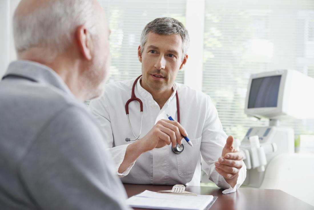 Doctor in office speaking to senior male patient
