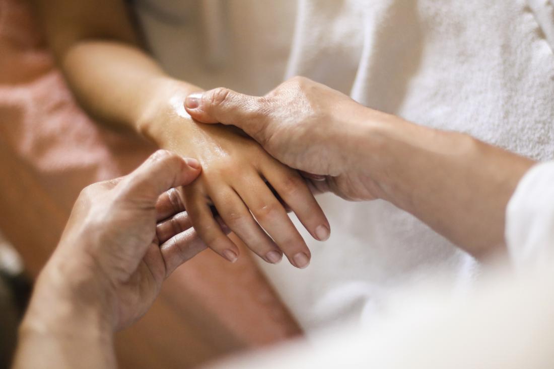 Acupressure therapy being applied to persons hand and wrist.