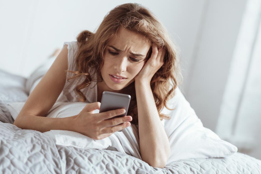 sad woman looking at phone