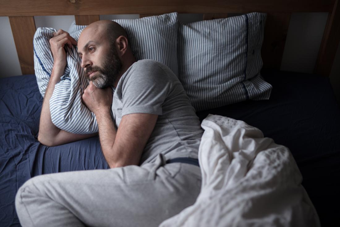 Man with insomnia lying in bed.