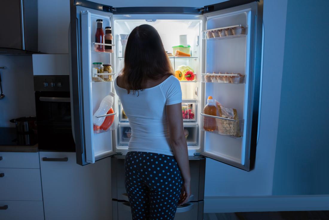 woman looking into fridge