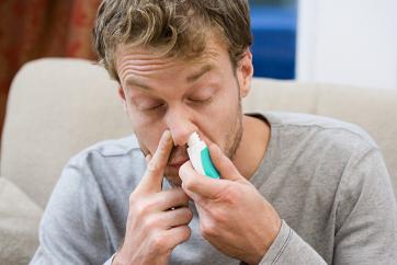 man using nasal decongestant