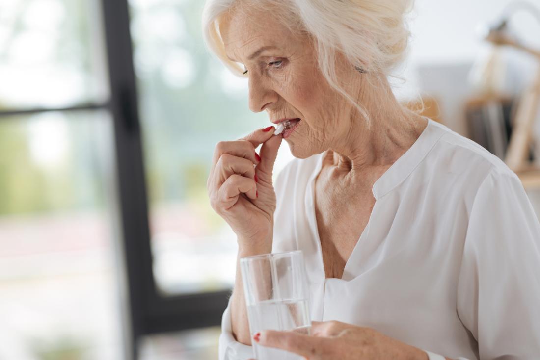 older lady taking a pill