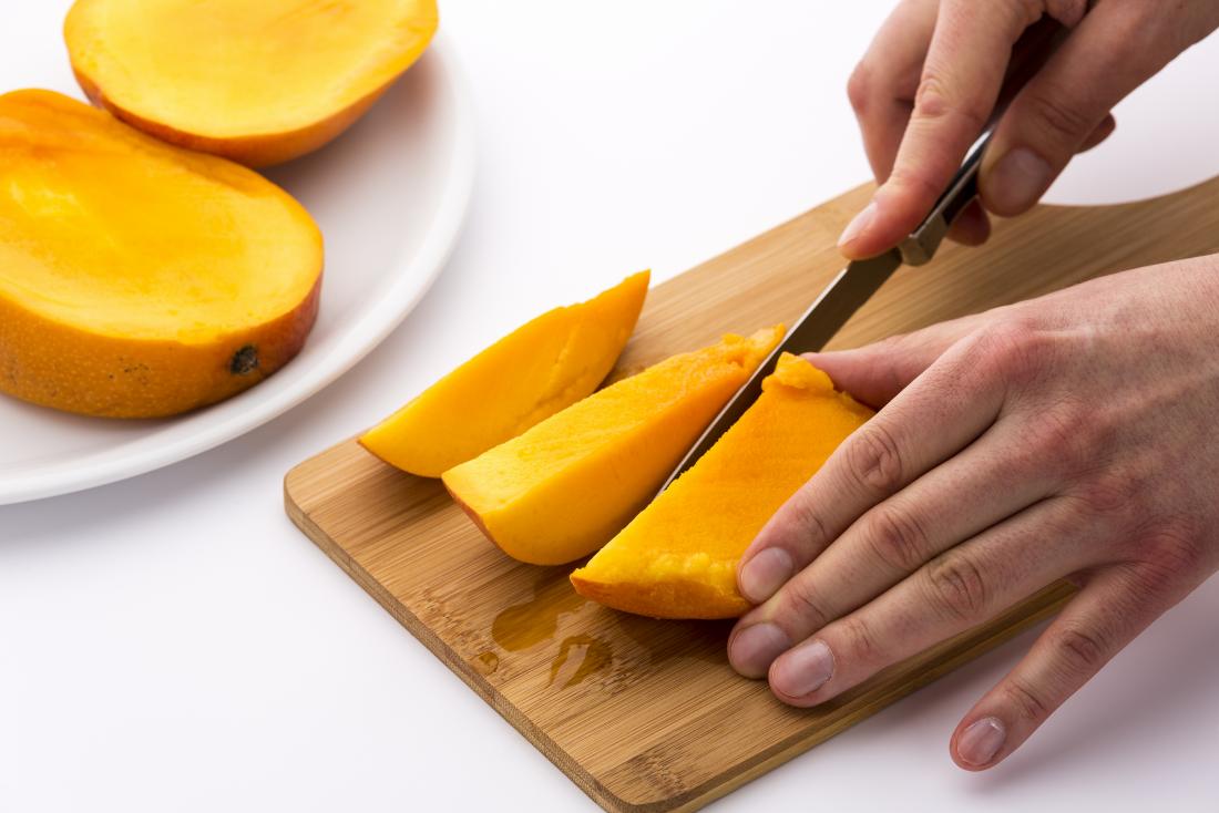 man slicing a mango