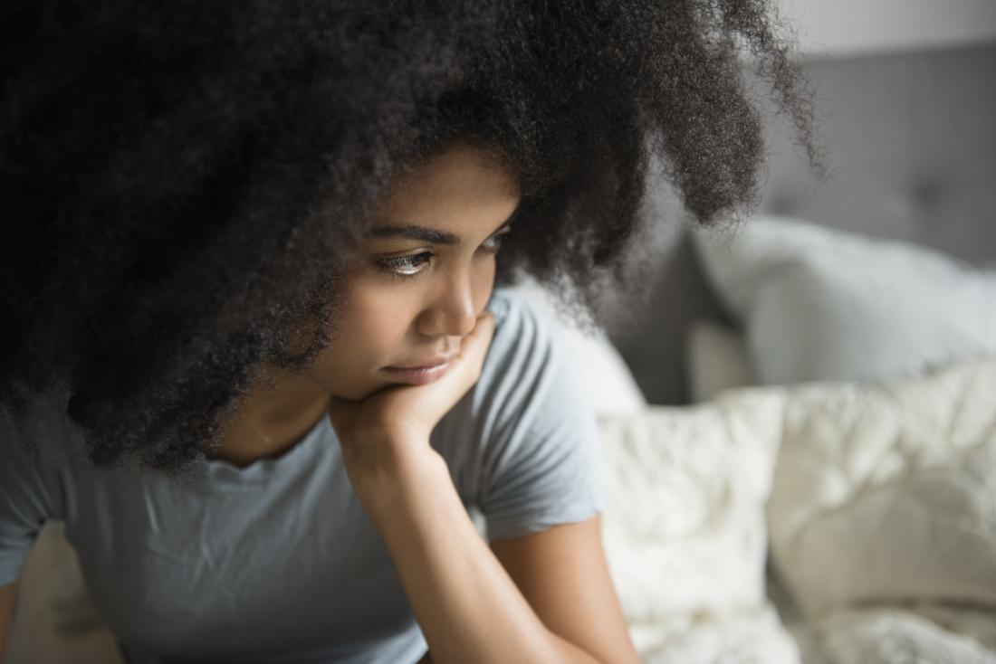 Woman thinking and contemplative, sad and anxious in bed