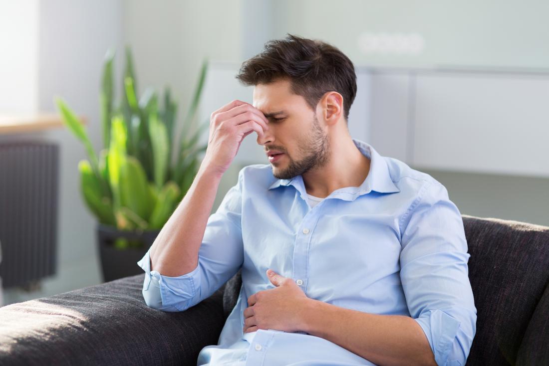 man with headache sitting on settee