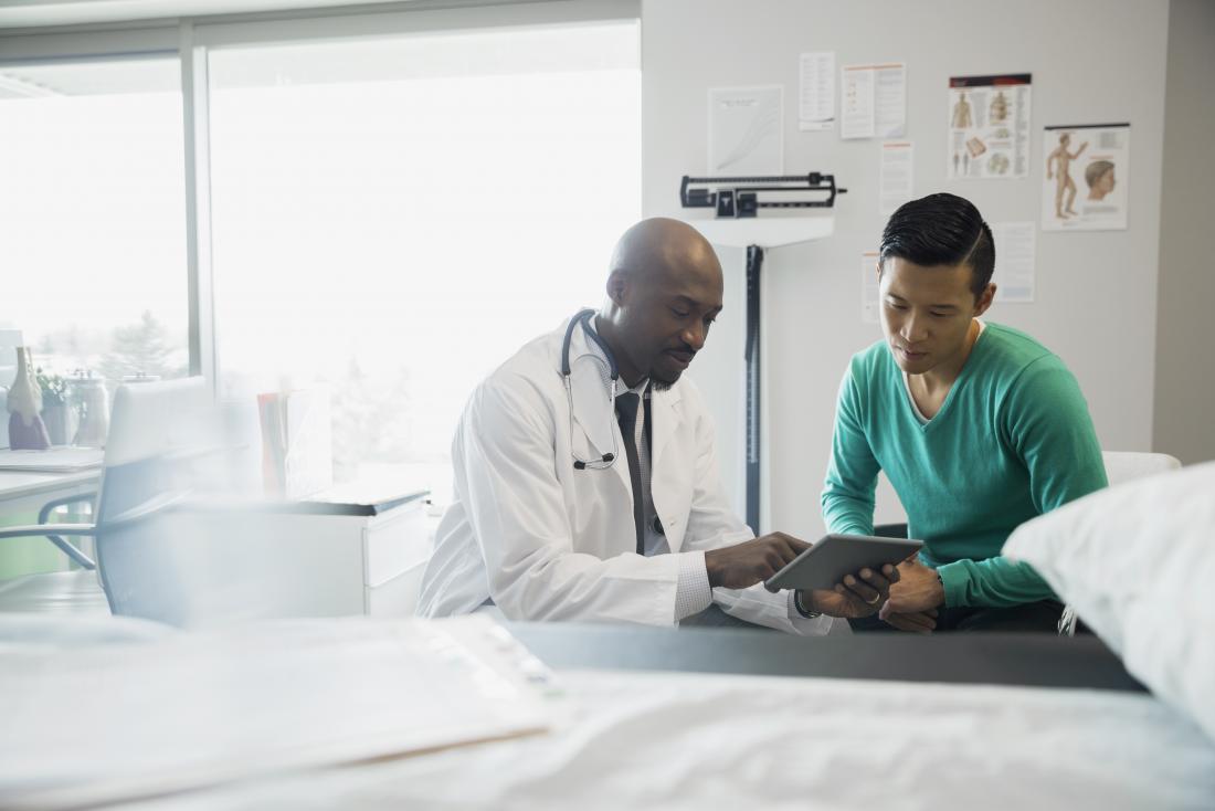 Doctor showing patient something on tablet.