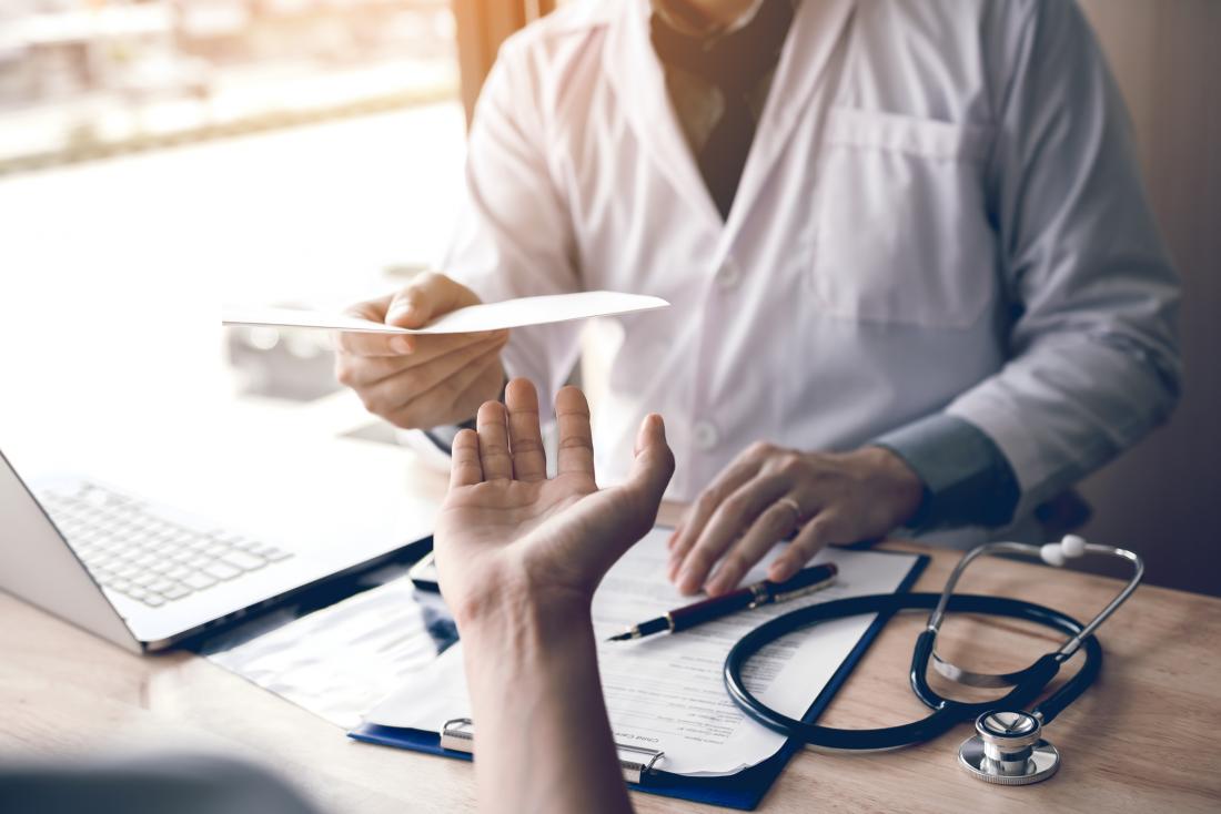Doctor handing over a prescription to a patient