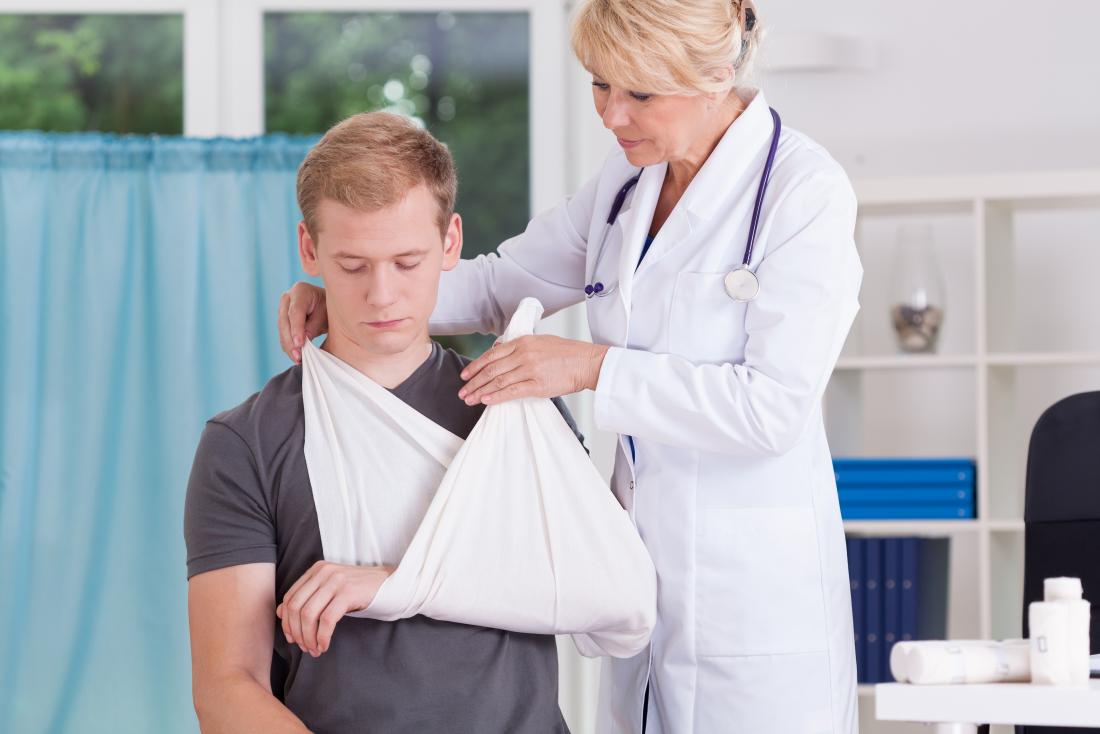 doctor fastening sling on male patients arm