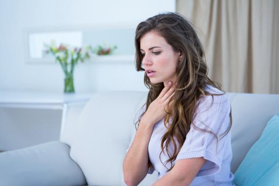 Woman experiencing shortness of breath holding her chest