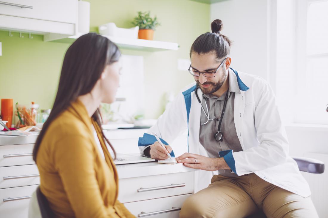 Doctor writing out prescription for patient