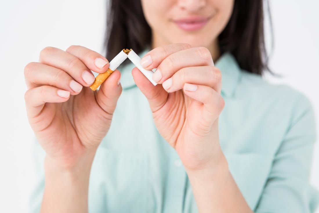 Woman breaking cigarette in half