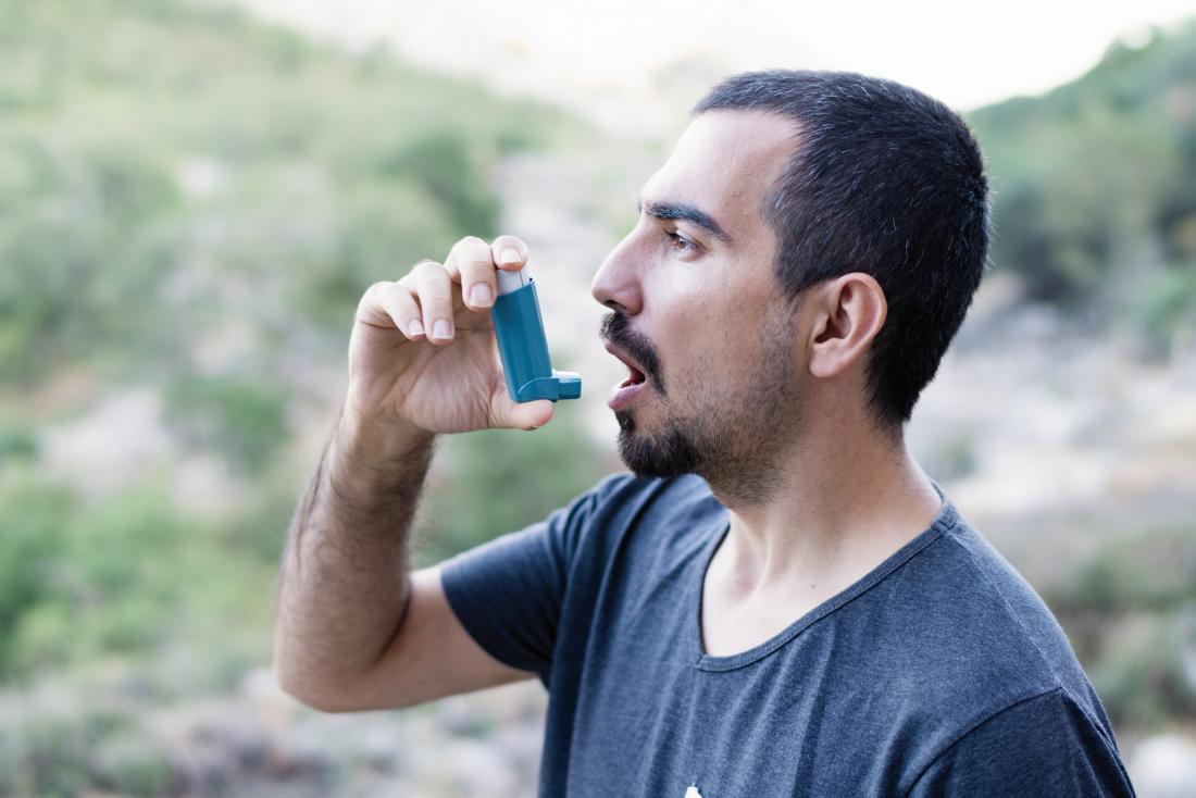 man takes inhaler