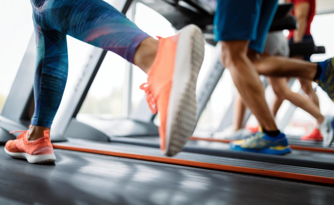 People running on treadmills in gym