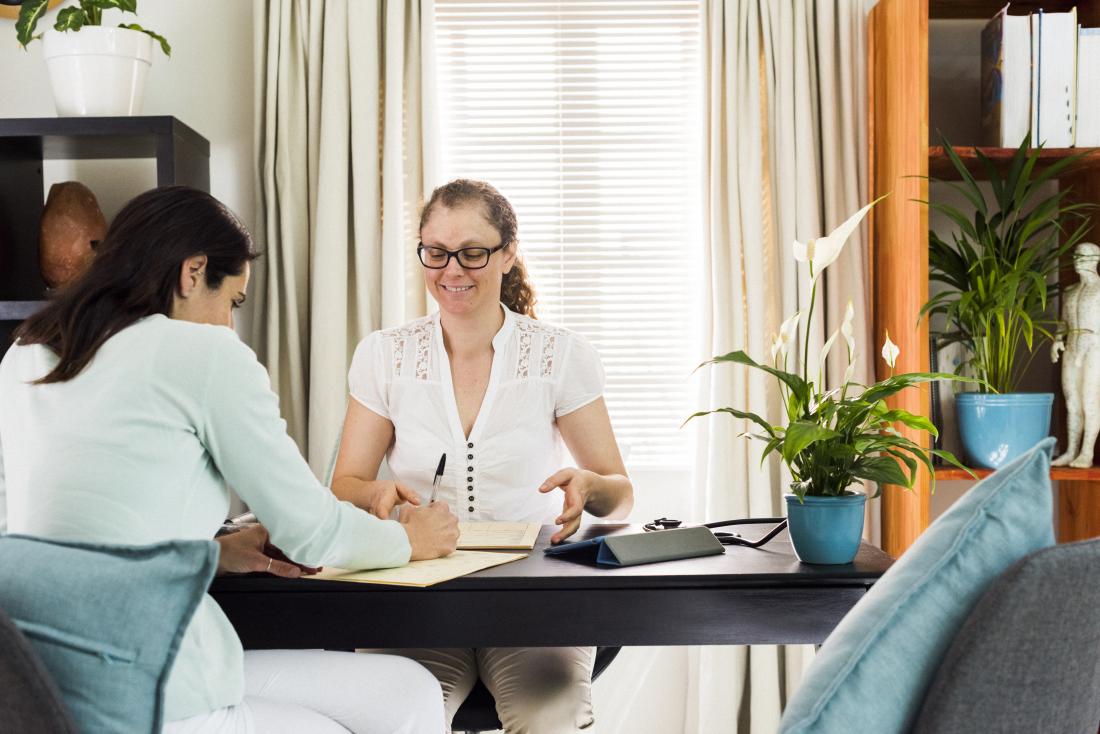 Alternative therapist in office getting patient to sign documents