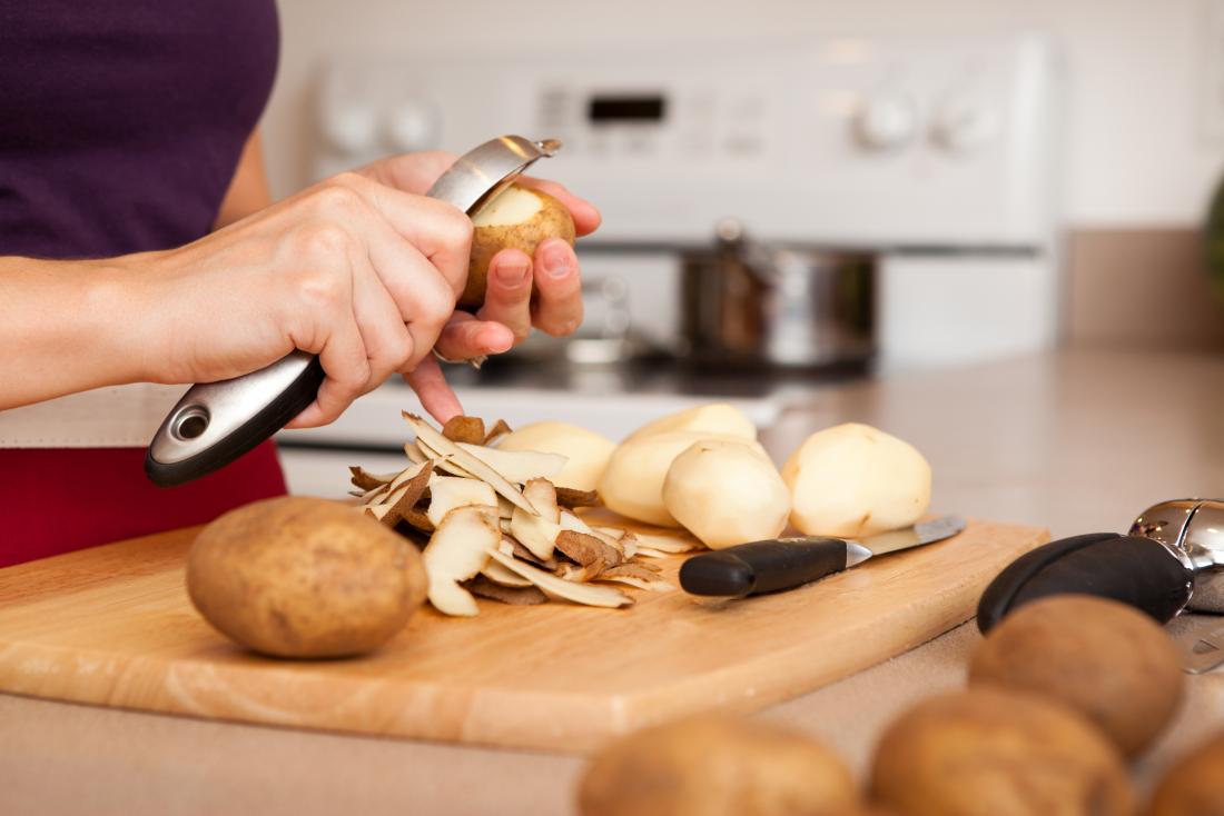 Person peeling potatoes