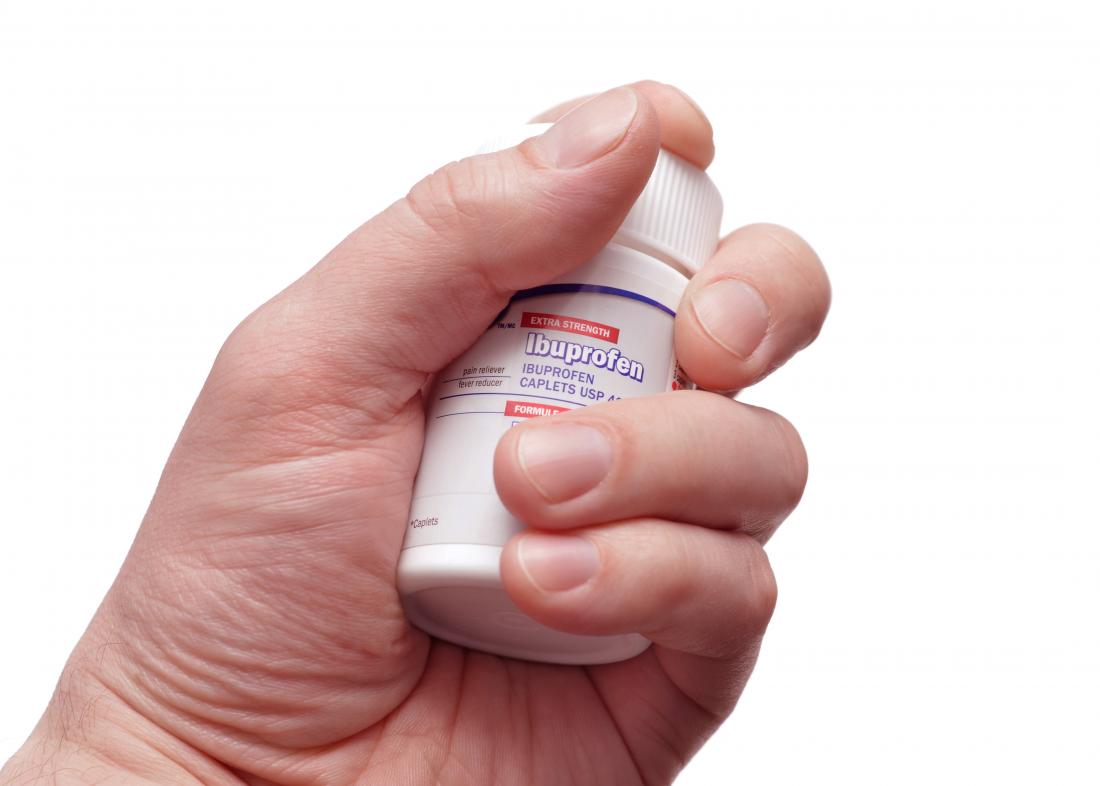 Hand holding ibuprofen bottle