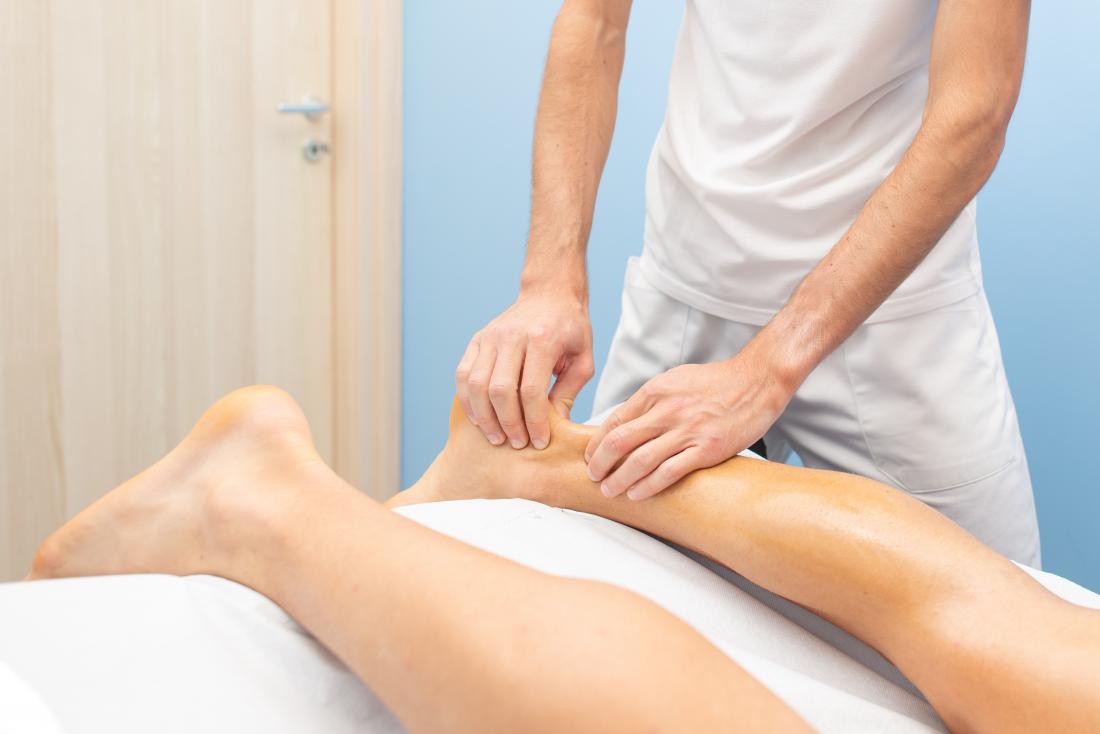 The Massage Process. Masseur`s Masculine Hands Soaked in Oil Knead