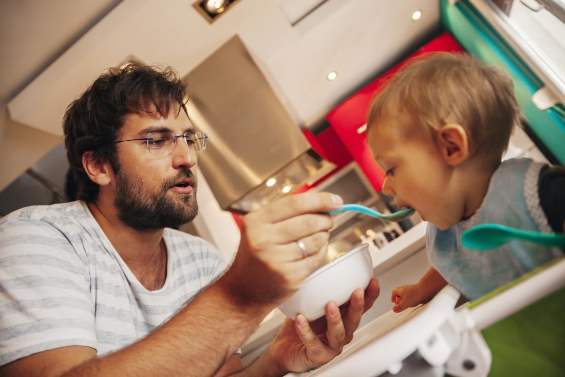 father feeding toddler