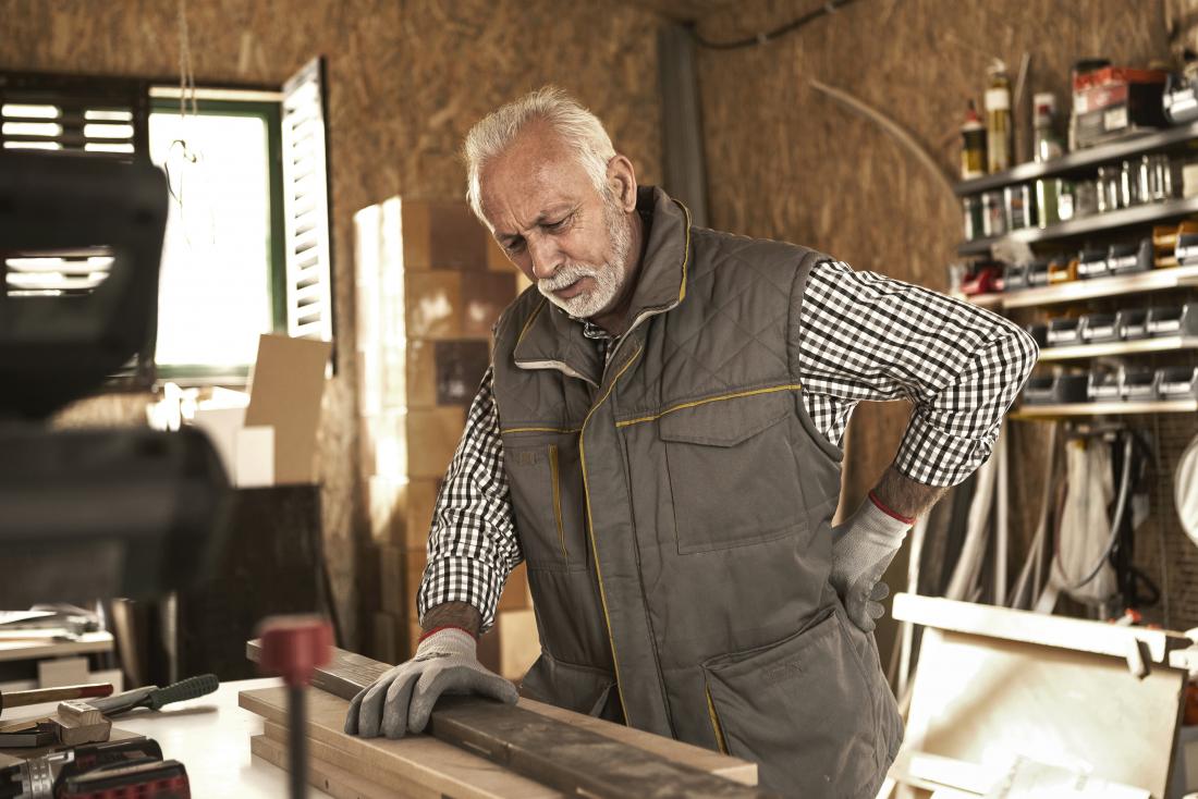 Man experiencing Lhermitte's sign while working in garage on woodwork