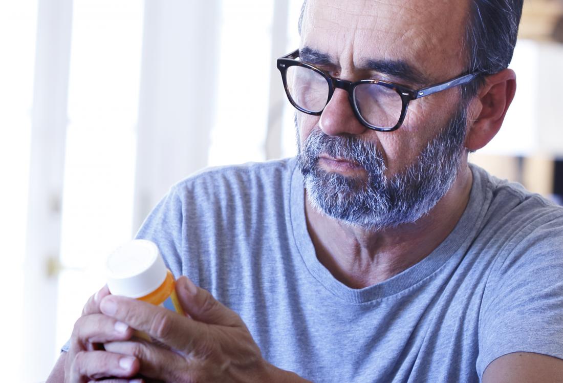 Man holding pill bottle of antiretroviral drugs for HIV