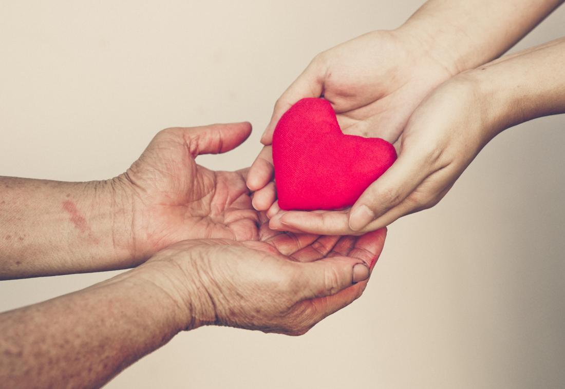 senior woman receiving heart from women's hands