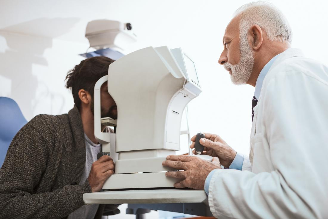 optician or Optometrist with optometry machine checking patient