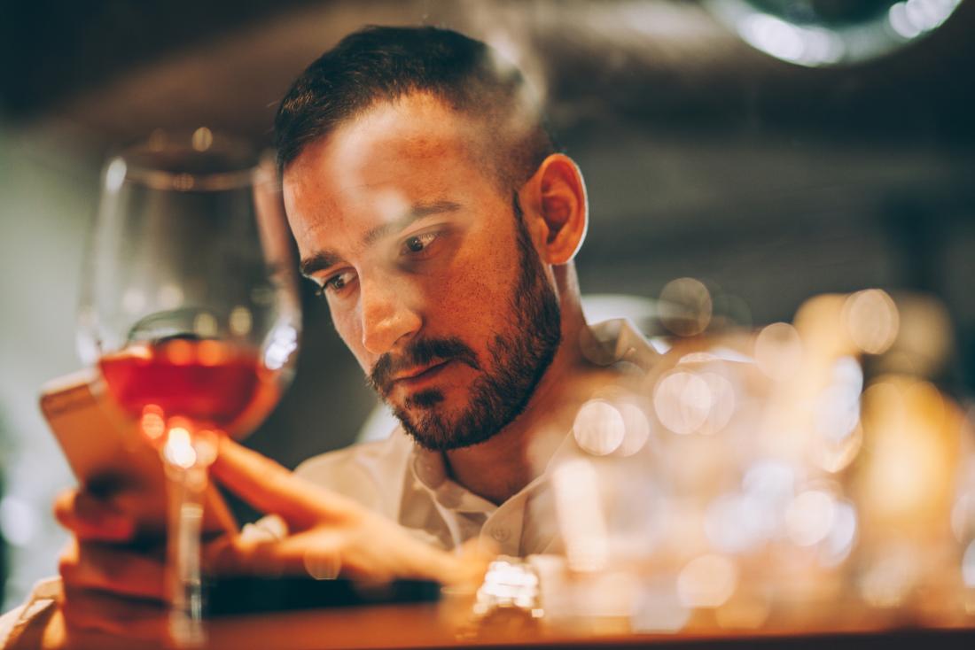man looking sad, checking phone