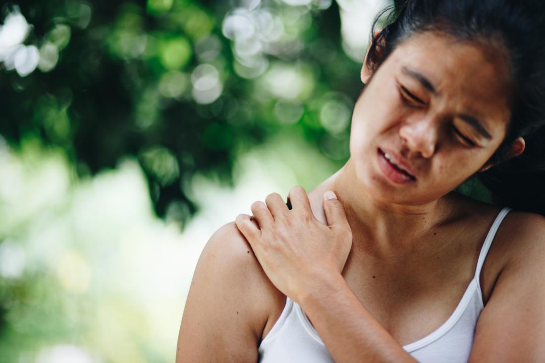 woman holding her shoulder in pain