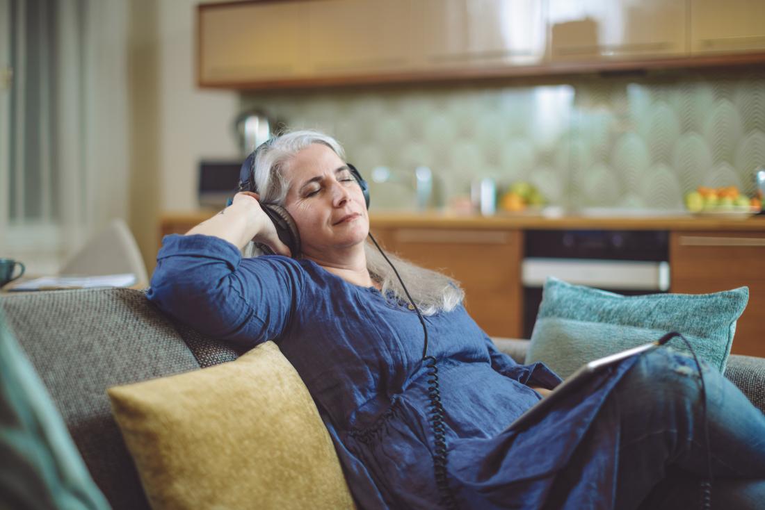 mature woman listening to music at home
