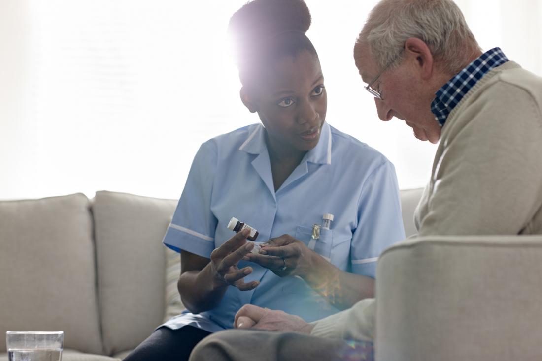 nurse giving senior drugs