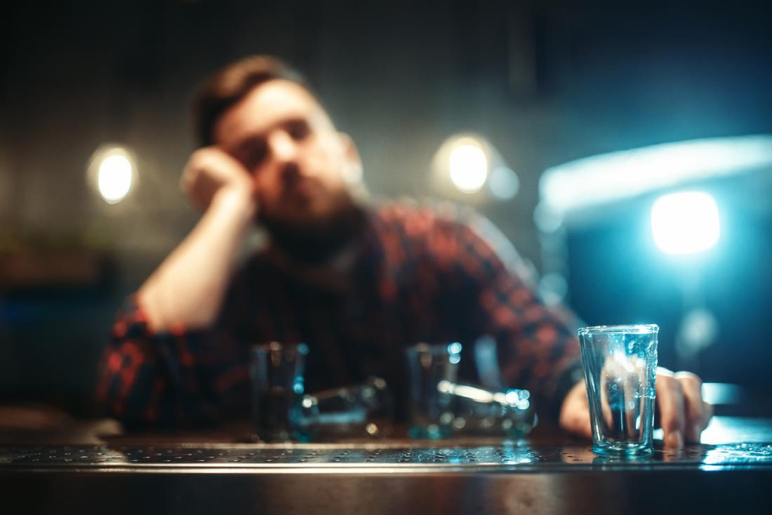 Man drinking shots alone
