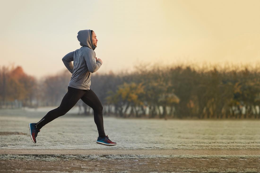 Man jogging or running through park in winter