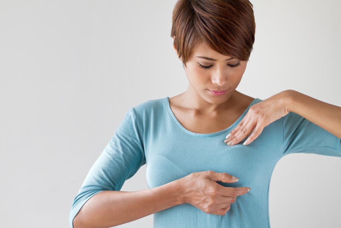 Woman checking for a lump on left breast