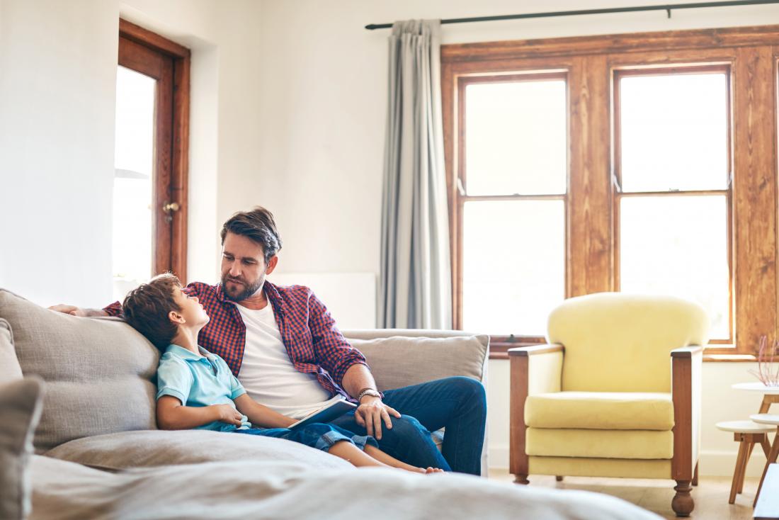 father and son sitting on sofa