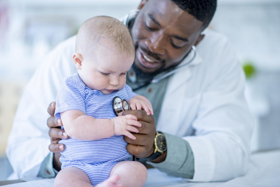 Doctor using stethoscope on baby