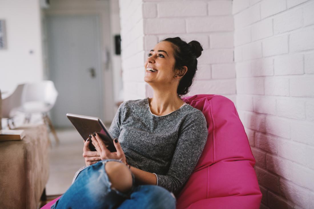 HAppy woman smiling and laughing sitting on beanbag