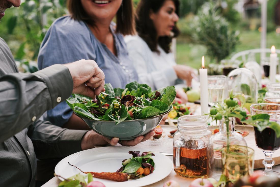 friends sitting around the table eating salad