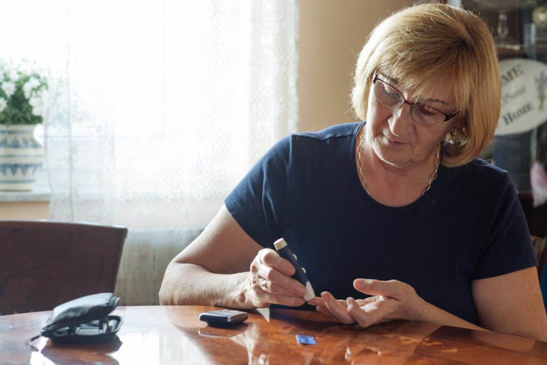 senior woman measuring her blood sugar