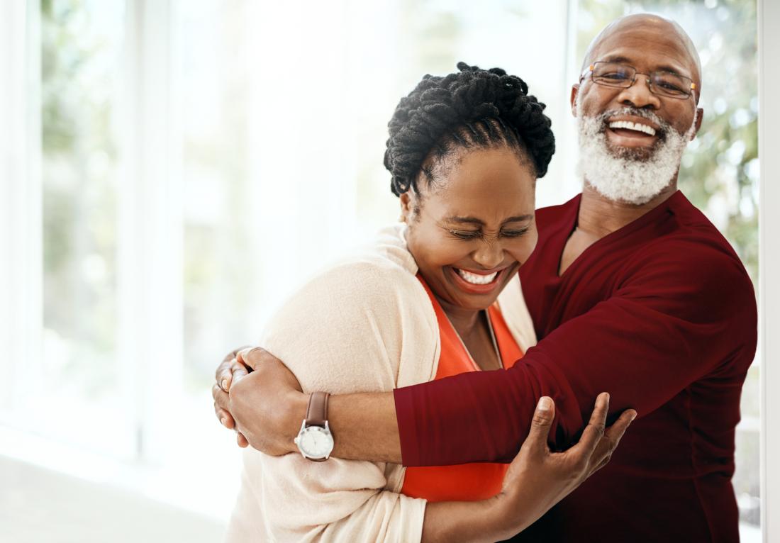 two seniors hugging laughing and looking happily in love