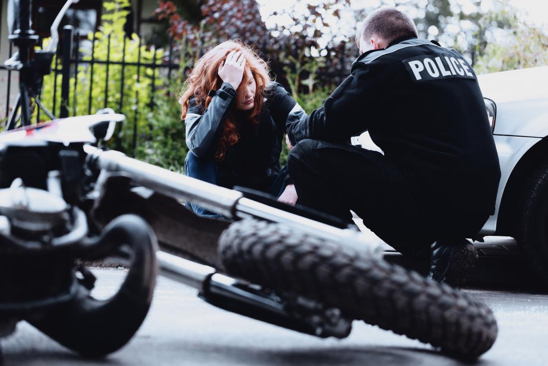 woman speaking to policeman after motorbike accident