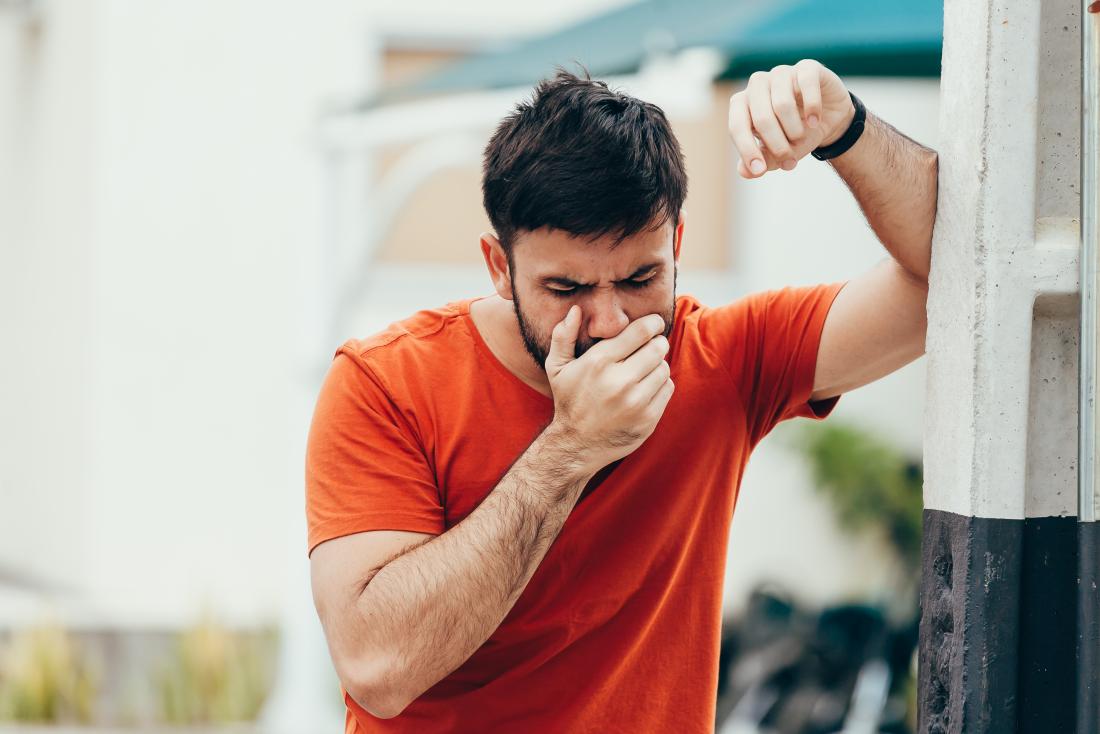 Man with nausea feeling sick holding hand over mouth