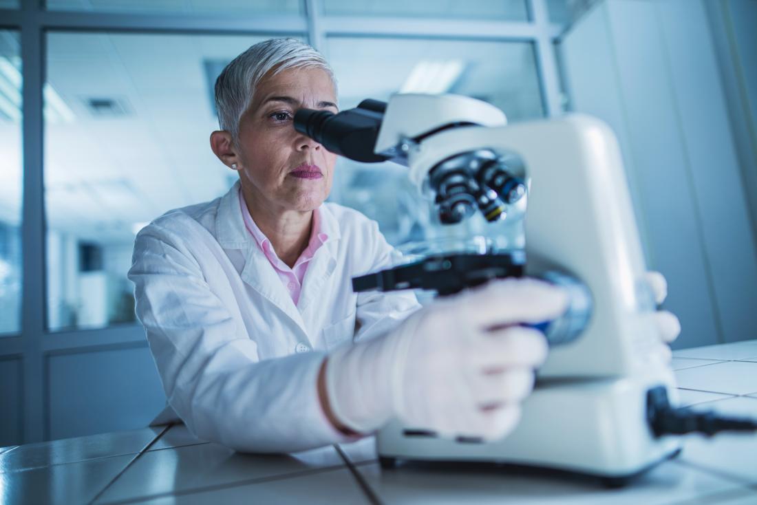 scientist looking through a microscope