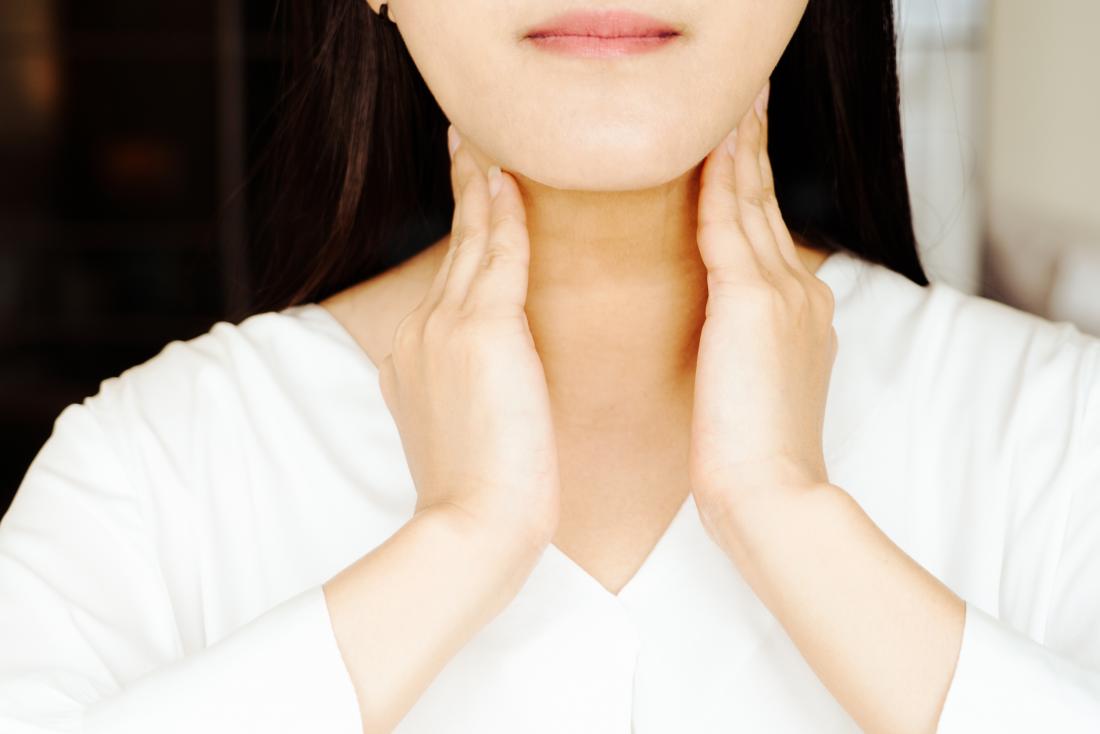 Woman holding her neck due to postnasal drip